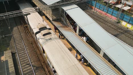 Aerial-shot-of-a-train-passing-through-the-station-with-passengers-]-in-Mumbai