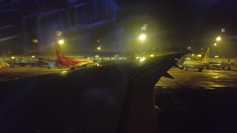 Through-the-window-view-of-Beijing-Capital-airport-from-taxiing-airplane-at-night