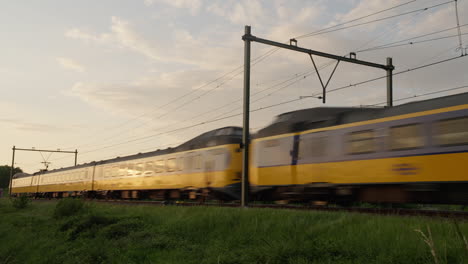 Characteristic-Dutch-train-"Koploper"-of-the-NS-passing-by-at-sunset-in-direction-of-Amersfoort