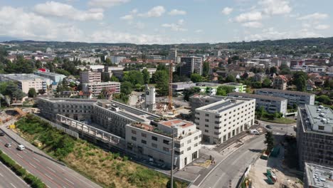 Eine-Drohne-Fliegt-Auf-Eine-Baustelle-Zu,-Die-Von-Wunderschönen,-Neu-Errichteten-Gebäuden-Umgeben-Ist