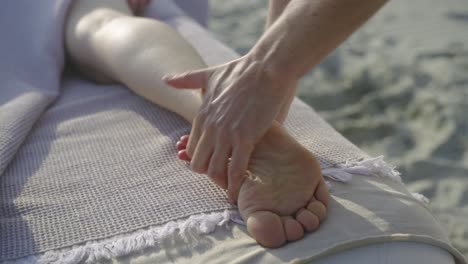 Eine-Entspannende-Fußmassage-Am-Strand-Unter-Der-Warmen-Sonne