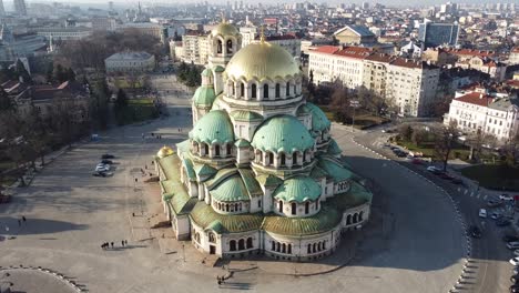 Aerial-orbital-drone-clip-circling-around-Alexander-Nevsky-Cathedral-anti-clockwise-in-the-Winter-sun-with-the-city-of-Sofia,-Bulgaria-in-the-background