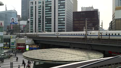 Futuristic-view-over-Tokyo-with-bullet-trains-passing-by-over-pedestrian-walkway