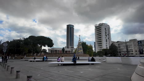 Una-Bulliciosa-Plaza-Pública-En-Nicosia,-Chipre,-Con-Modernas-Zonas-Para-Sentarse-Y-Un-Telón-De-Fondo-De-Edificios-Altos,-Capturada-En-Cámara-Lenta.