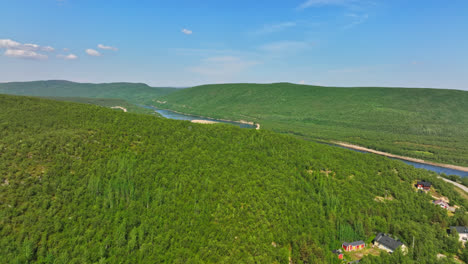 Drone-rising-over-arctic-hills,-revealing-the-Teno-river,-in-sunny-Utsjoki,-Finland