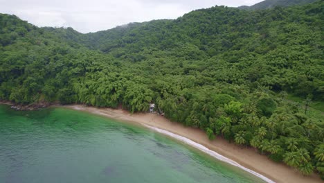 Drone-flying-away-from-lonely-house-surrounded-by-water-and-trees