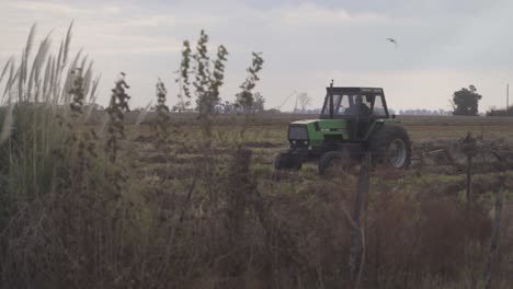 Vista-Manual-De-Un-Tractor-Acercándose-Mientras-Se-Siembra-El-Suelo-En-Preparación-Para-La-Siembra