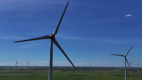 Las-Turbinas-Eólicas-Giran-En-Un-Vasto-Campo-Verde-Bajo-Un-Cielo-Azul-Claro.