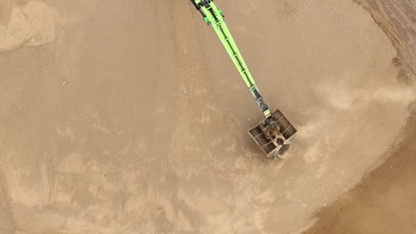 An-aerial-view-of-a-large-dump-truck-filled-with-sand,-showing-tire-tracks-and-the-surrounding-worksite