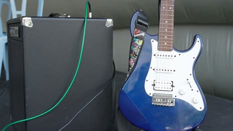 Guitarra-Eléctrica-Azul-Aislada-Junto-Al-Amplificador-En-El-Escenario.