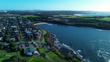 Landscape-coastline-view-of-Malabar-beach-town-ocean-waves-bay-street-roads-housing-homes-in-Maroubra-Randwick-Sydney-city-Australia-drone-aerial