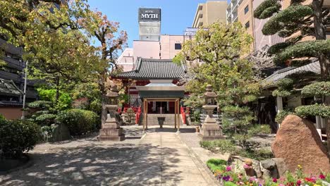 Antiguo-Templo-Budista-Con-Un-Moderno-Edificio-De-Hotel-Al-Fondo-En-Osaka,-Japón.