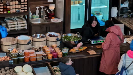 El-Personal-Del-Mercado-De-Agenskalns-Mientras-La-Mujer-Compra-Comida-En-La-Cafetería,-Un-Alto-ángulo-De-Vista-Mirando-Hacia-Abajo