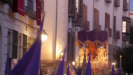 Una-Carroza-De-&quot;paso&quot;-Con-Una-Estatua-De-La-Virgen-María-Se-Mece-Suavemente-Entre-Capirotes-Morados-Sobre-La-Multitud