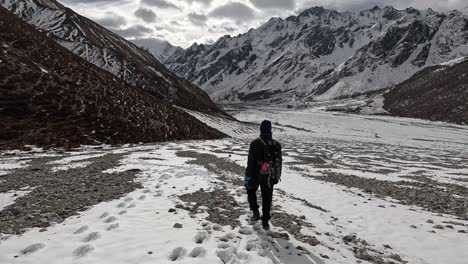 Following-hiker-descending-in-glacial-moraine-plains