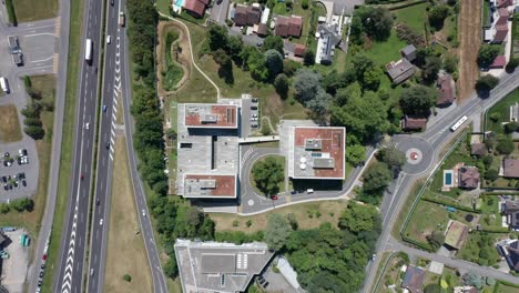 Top-down-view-of-a-luxury-apartment-complex-next-to-a-busy-highway