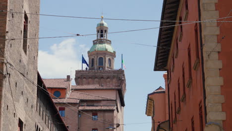 Historic-tower-peeks-between-old-buildings-under-blue-sky