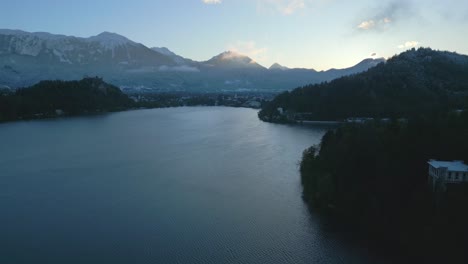 Luftaufnahme-Des-Bleder-Sees-In-Slowenien,-Umgeben-Von-Den-Gipfeln-Der-Slowenischen-Alpen-Bei-Sonnenaufgang
