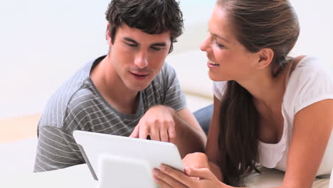 Smiling-couple-using-a-tablet-pc