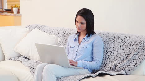 Mujer-Usando-Una-Computadora-Portátil-Mientras-Está-Sentada