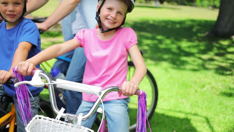 Un-Niño-Y-Una-Niña-Sentados-Uno-Al-Lado-Del-Otro-En-Bicicleta-En-Un-Parque.