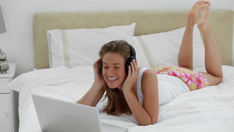 Joyful-woman-listening-to-music-in-front-of-her-laptop