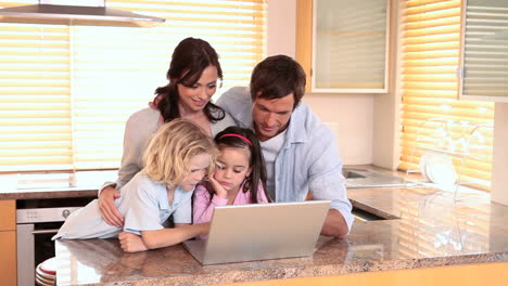 Familia-Mirando-Una-Computadora-Portátil-Juntos