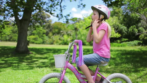 Girl-puts-on-a-cycling-helmet-and-holds-the-handle-bars