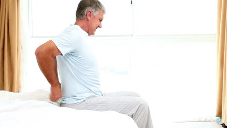 Seitenansicht-Eines-Mannes-Mit-Rückenschmerzen-Auf-Der-Bettkante