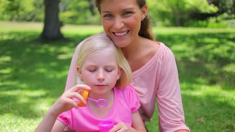 Girl-blowing-bubbles-with-her-mother-