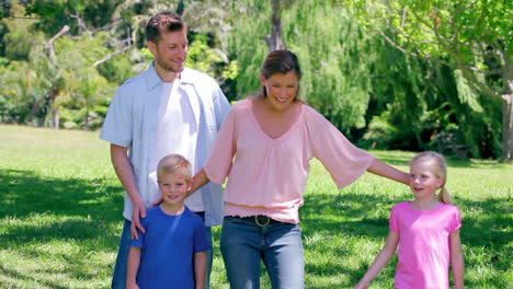 Boy-kicking-a-ball-as-he-walks-in-the-grass-with-his-family