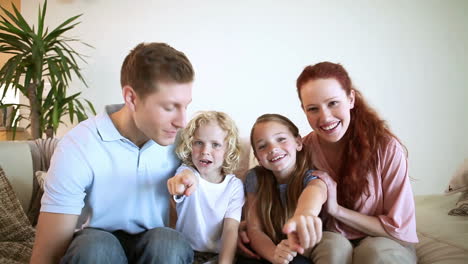 Happy-family-sitting-down-looking-at-the-camera