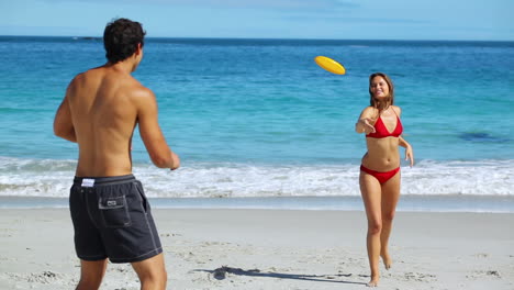 Smiling-couple-playing-frisbee