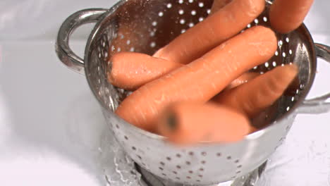 Carrots-falling-into-sieve-in-super-slow-motion