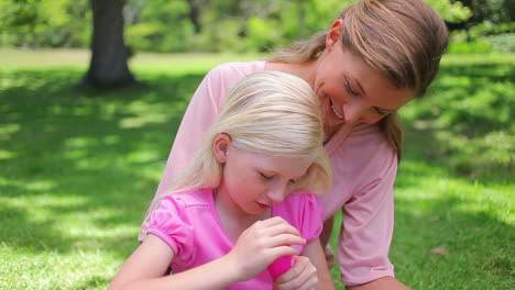 Eine-Mutter-Hilft-Ihrer-Tochter-Seifenblasen-Zu-Machen