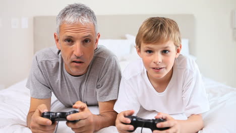 Smiling-father-and-son-playing-video-games