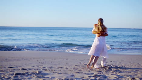 Man-catching-and-turning-his-girlfriend-on-the-beach