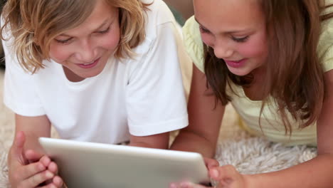 Smiling-siblings-using-a-tablet-computer
