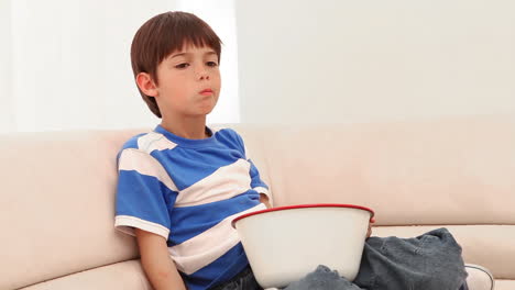 Boy-eating-popcorn-while-he-watches-television
