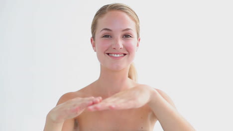 Smiling-woman-applying-moisturizer-on-her-hand