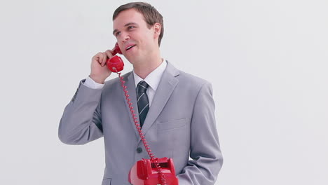 Happy-businessman-using-a-red-phone