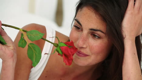 Woman-smelling-a-red-rose