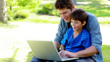 Boy-on-his-fathers-tigh-using-a-laptop