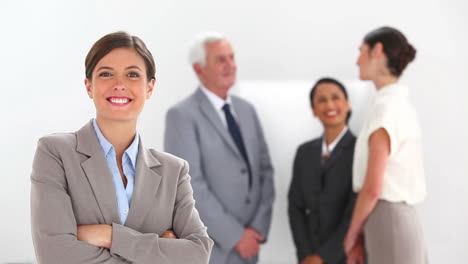 Businesswoman-posing-with-colleagues-talking-