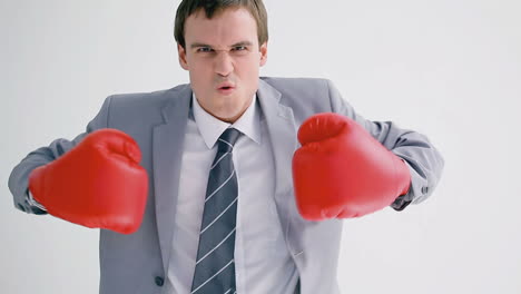 Business-man-playing-with-red-boxing-gloves