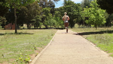 A-woman-jogs-past-the-camera-and-down-a-footpath