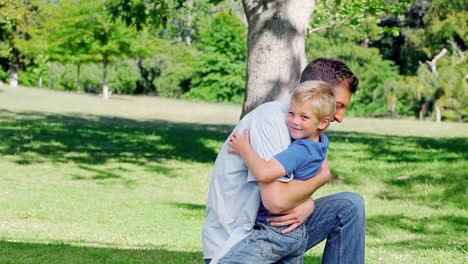 Father-kneels-on-the-grass-before-hugging-his-son-who-runs-to-him