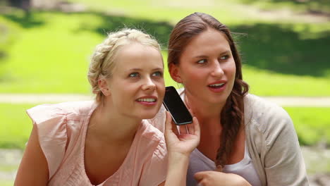 Two-shocked-women-listen-to-someone-on-the-phone-