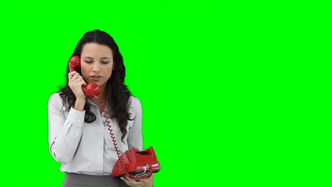A-business-woman-using-a-red-telephone-