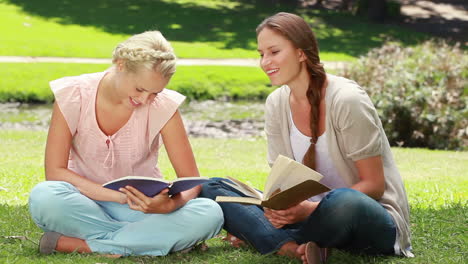 Two-ladies-reading-in-the-park-as-they-then-look-at-the-camera